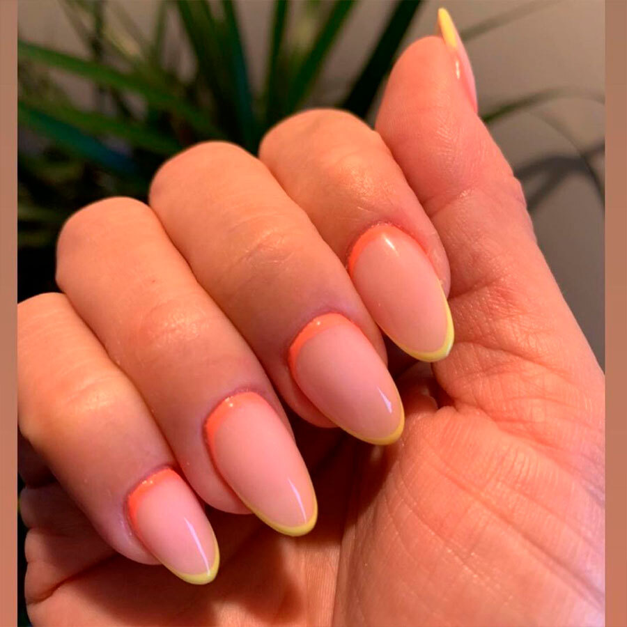 A person with yellow tips on their nails.