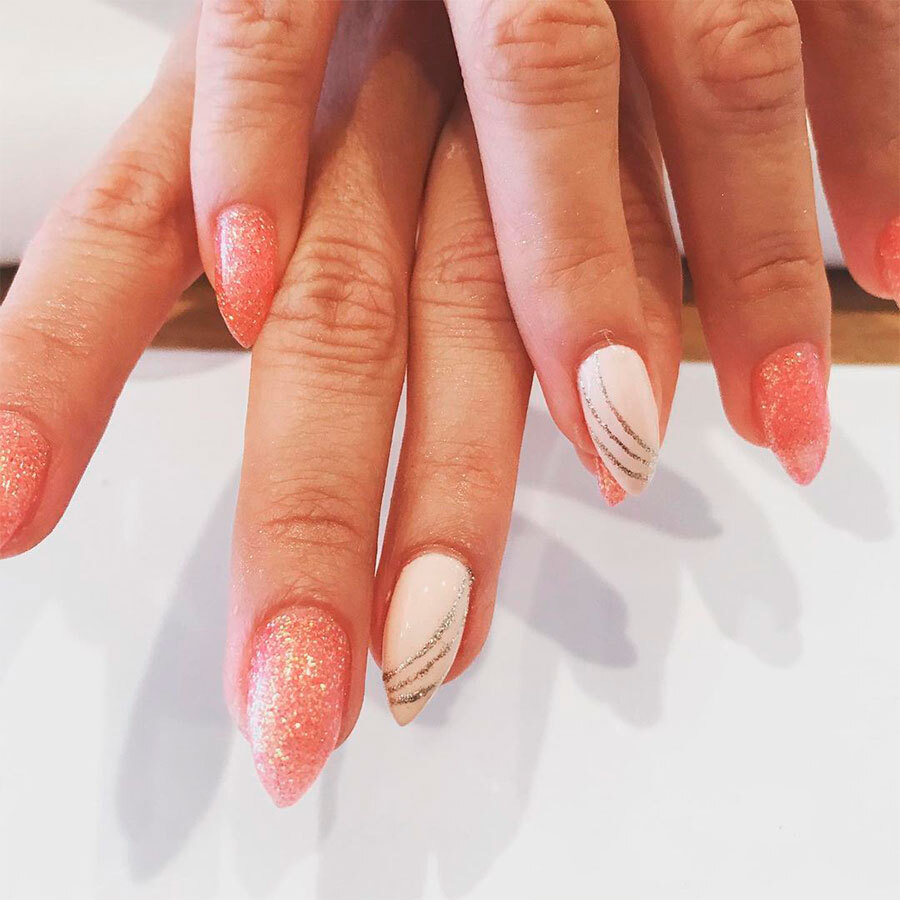 A woman 's hands with pink and white nails.