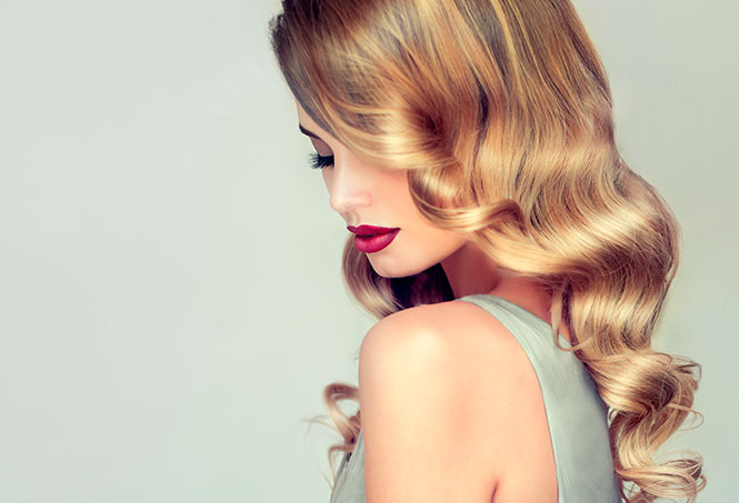 A woman with long blonde hair and red lipstick.